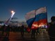 Болельщики с российским флагом на фоне олимпийского факела Сочи-2014 на Medal Plaza
